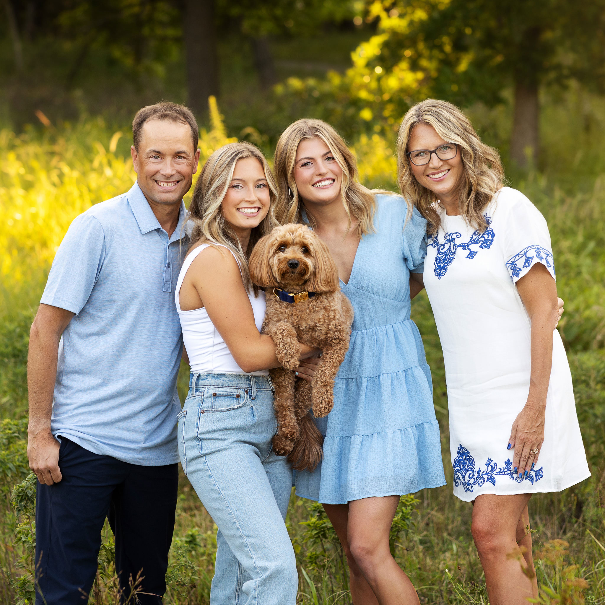 Family cuddling together with their dog during a family session in Monticello MN park