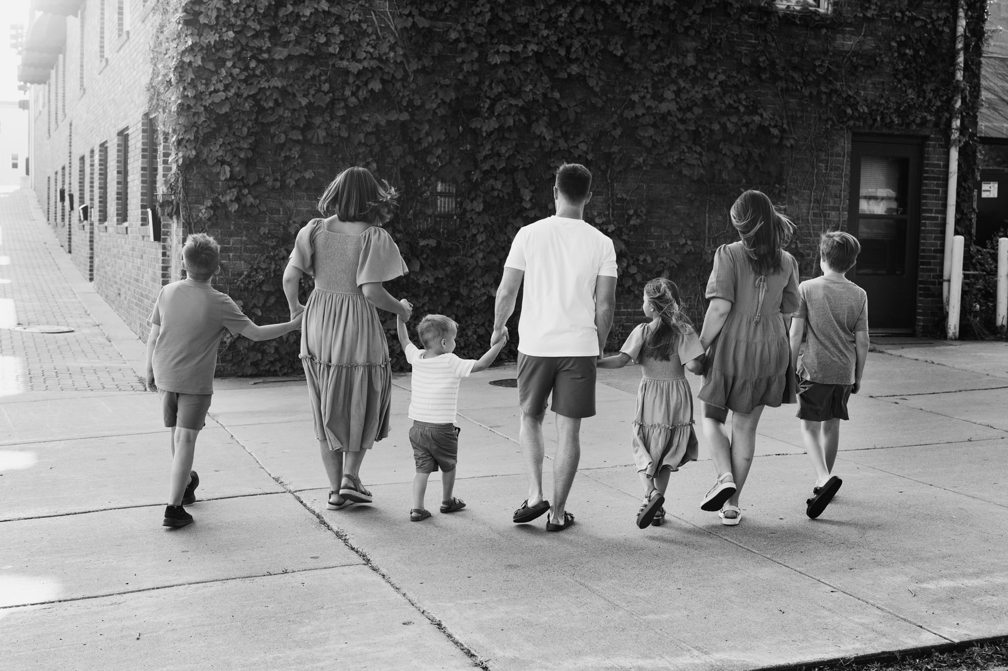 black and white urban family photo of family walking downtown