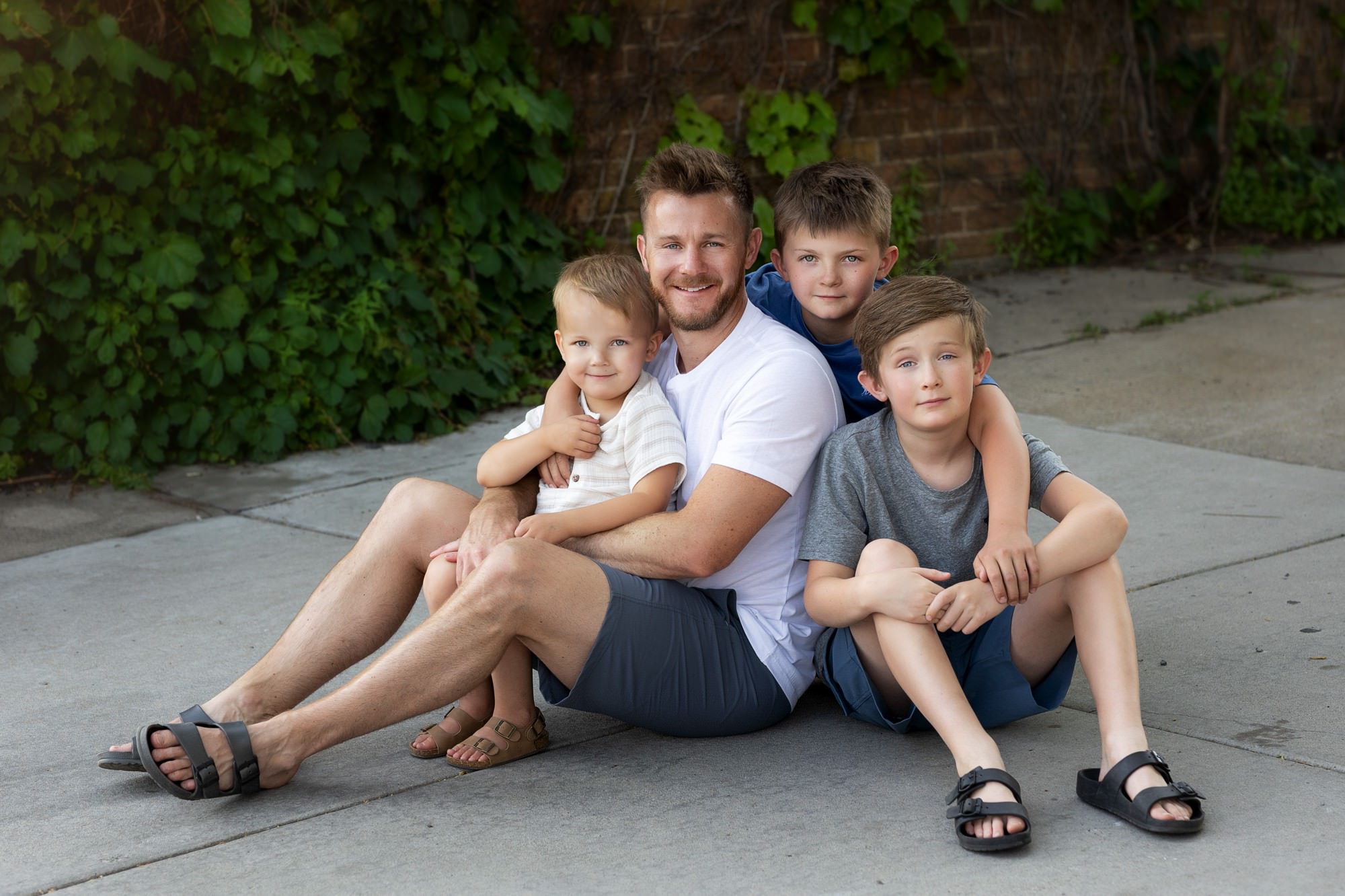 dad with sons in urban alleyway during Minnesota family pics