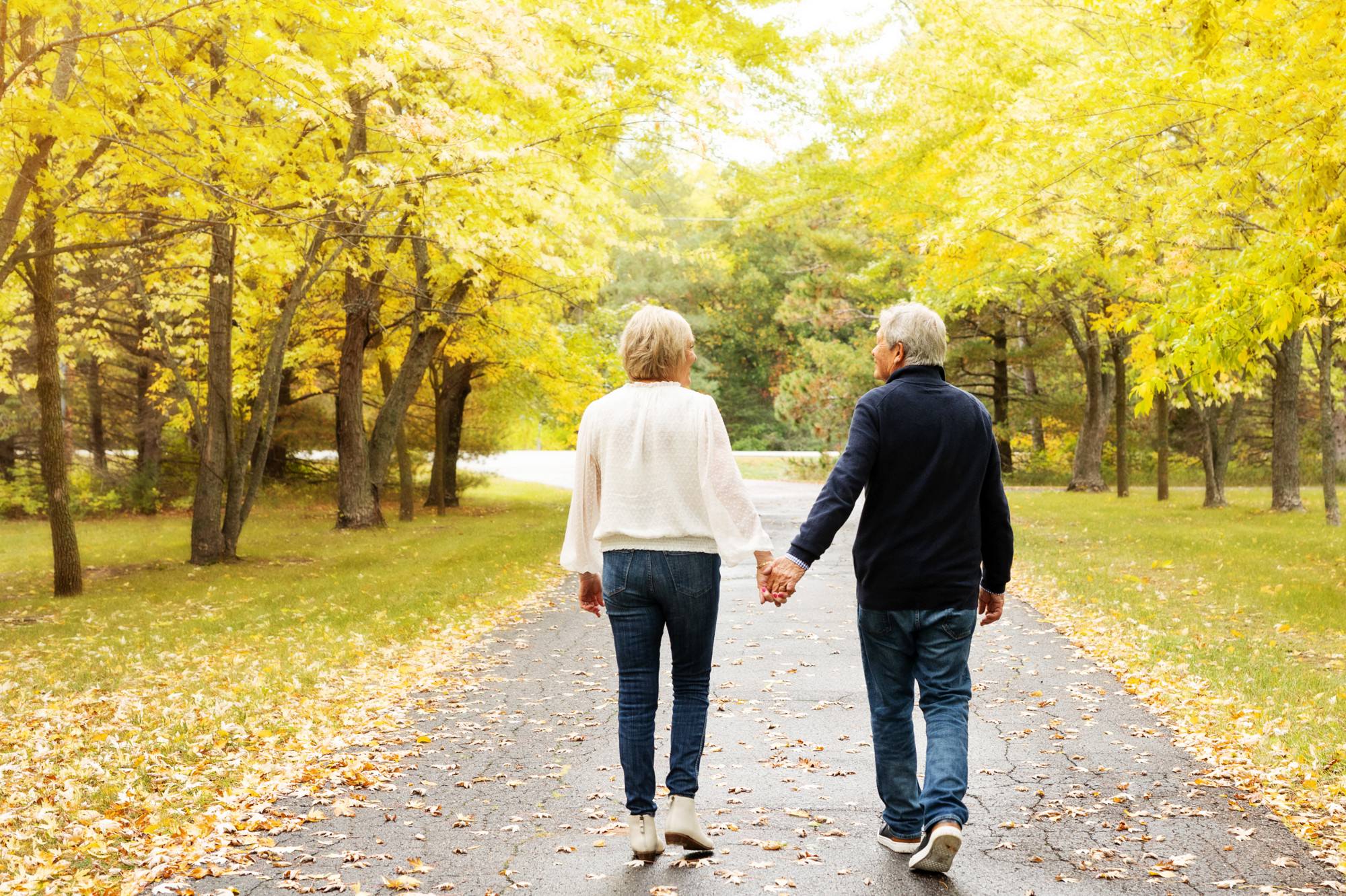 Couple walks down their Central MN driveway during family photos