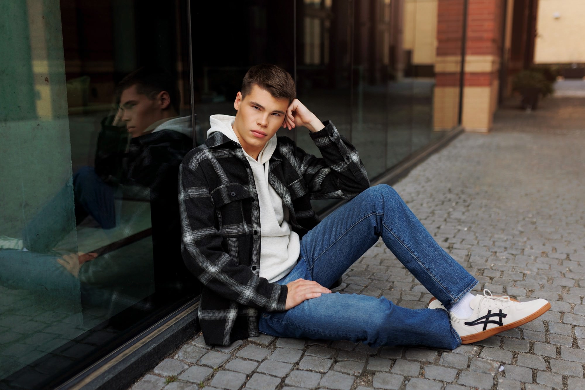 senior photos of senior guy showing full casual outfit including jeans and layered tops and cool sneakers