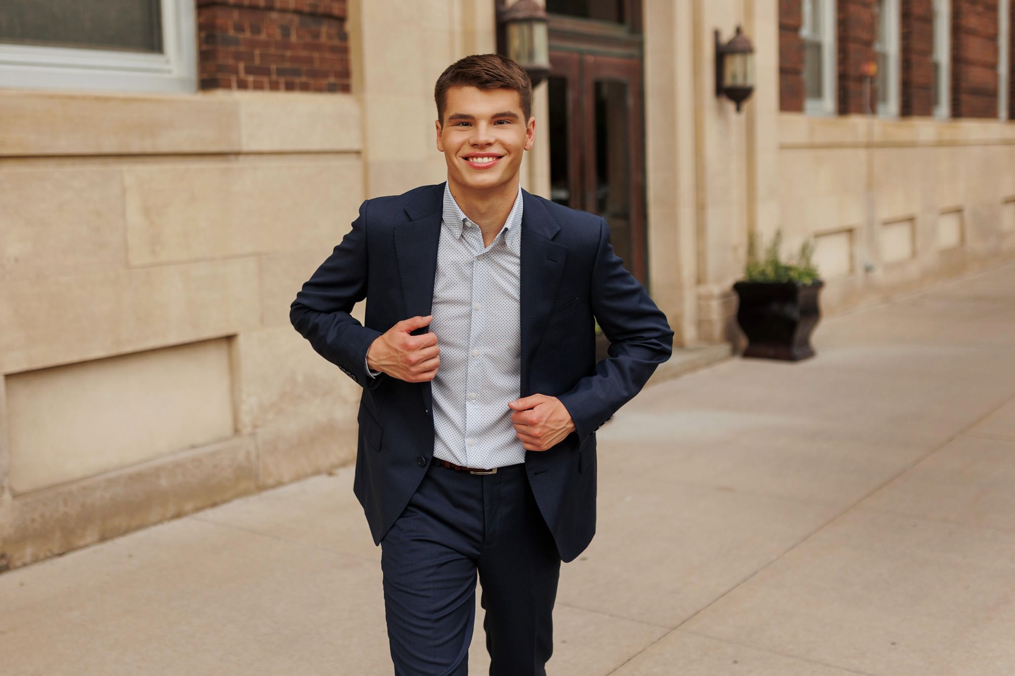 senior guy running in a formal suit in downtown Minneapolis