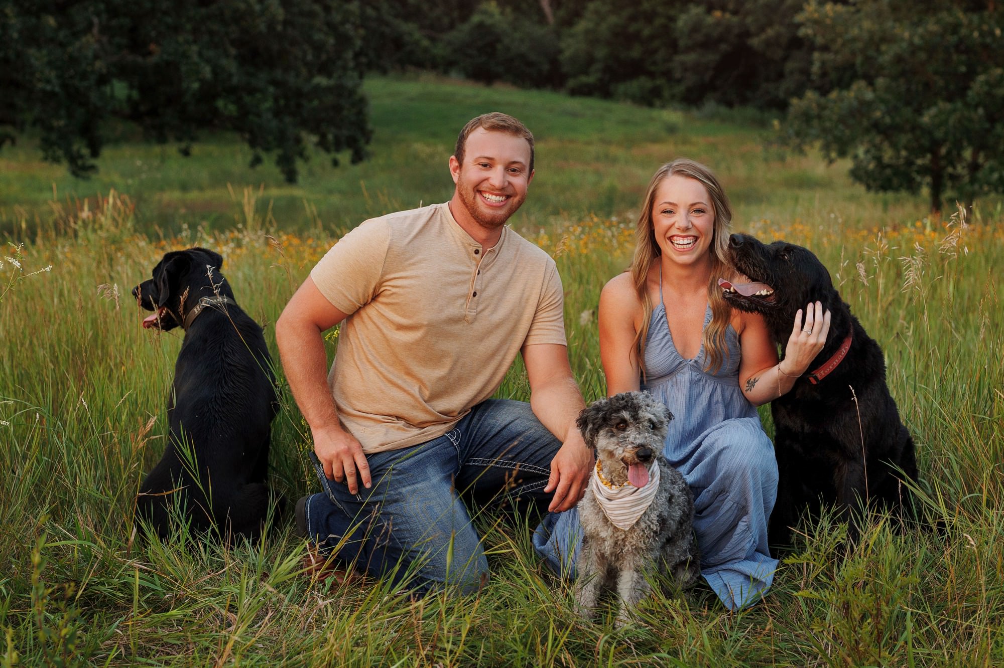 A funny candid photo of young couple with their dogs during Minnesota summer family photo session