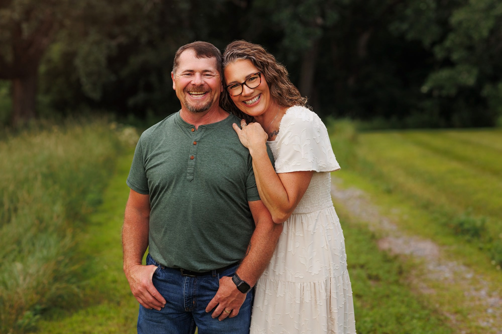 Mom and dad smiling together during a family photography session on their Minnesota property.